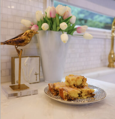 Squares of Family Savvy's Honey Bun Cake sitting on a plate on a marble kitchen counter