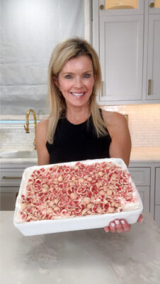Jamie Tarence of Family Savvy in her kitchen holding the 4-ingredient frozen strawberry cheesecake dessert