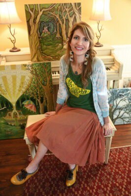 Amy Grimes of Story Paintings sitting in front of her air pieces