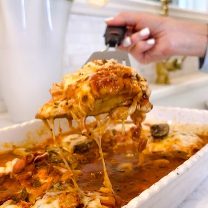 Mozzarella & Pepperoni Chicken being lifted from a white casserole dish with melted cheese stretching and rich tomato sauce — Family Savvy