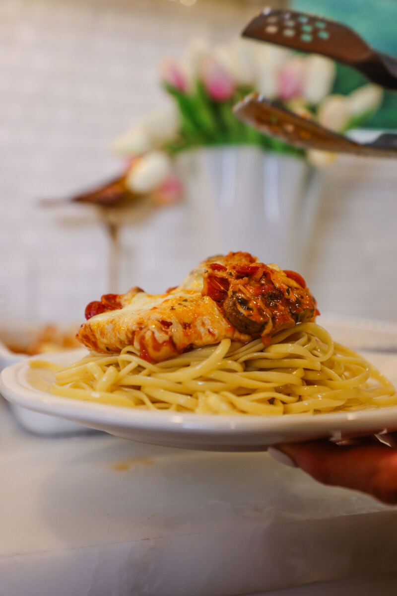 Close-up of Mozzarella & Pepperoni Chicken Bake served over linguine pasta, topped with melted mozzarella, pepperoni, and tomato sauce — Family Savvy