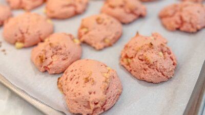 Close-up of several strawberry white chocolate chip cookies on a cookie sheet