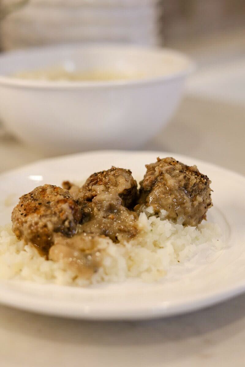 Swedish Meatballs served over white rice on a white plate