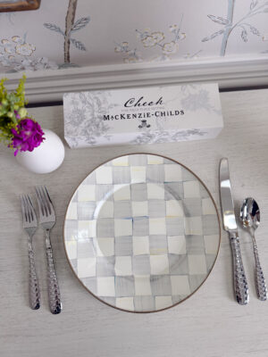 Mac-Kenzie Childs Blue Check Plate with their checkered flatware on a white table