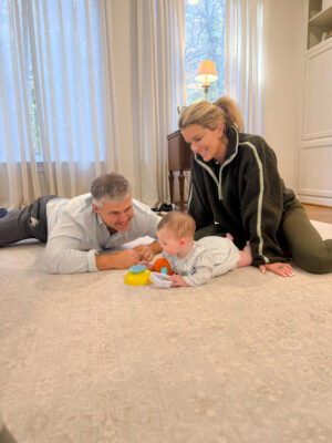 Jamie Tarence of Family Savvy sitting on the floor with her husband Zane and granddaughter Anne Parker