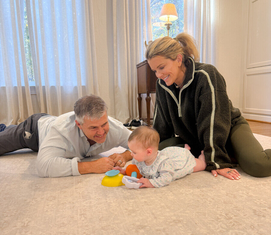 Jamie Tarence of Family Savvy sitting on the floor with her husband Zane and granddaughter Anne Parker