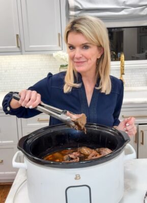Jamie Tarence of Family Savvy holding a pair of tongs with a chunk or rump roast in it