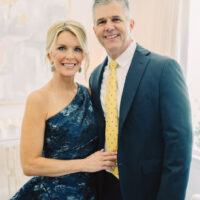 Photo of Jamie wearing a one-shoulder blue formal dress with her husband Zane wearing a suit