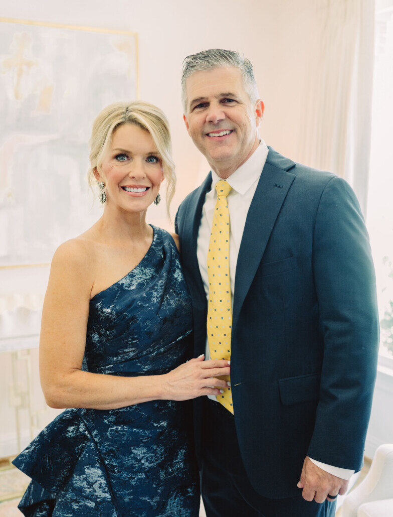 Photo of Jamie wearing a one-shoulder blue formal dress with her husband Zane wearing a suit