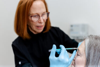 Dermatologist Dr. Jo Lynne Herzog, who is experienced in Botox and facial fillers, injecting a patient's forehead