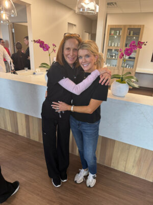Jamie Tarence of Family Savvy hugging her dermatologist, Dr. Jo Lynne Herzog, in the Elite Skin office