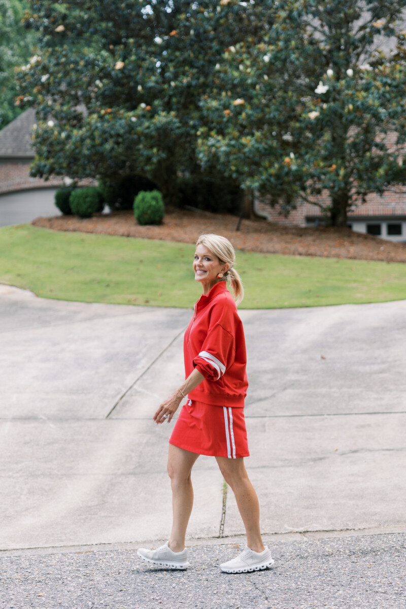 Jamie Tarance dressed in a red outfit walking outside her home.