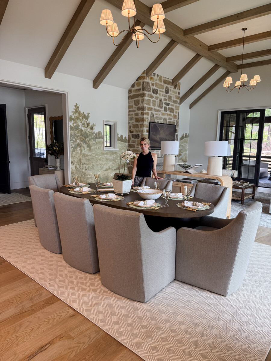Jamie Tarence wearing a black shirt and pants, standing beside a table in her lake home.