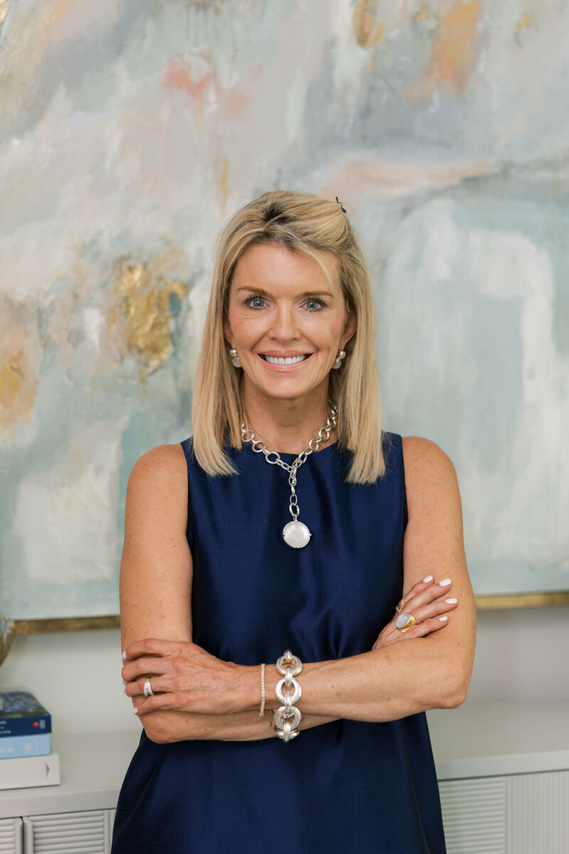Jamie Tarence of Family Savvy posing with her arms crossed in front of a piece of artwork
